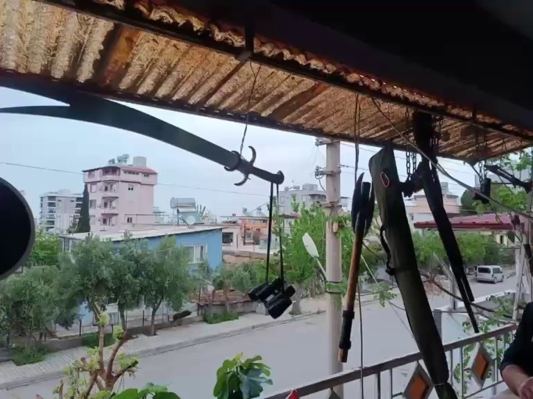 Balkonda silah, balta ve kılıç sergileyen şahıs hayrete düşürdü
