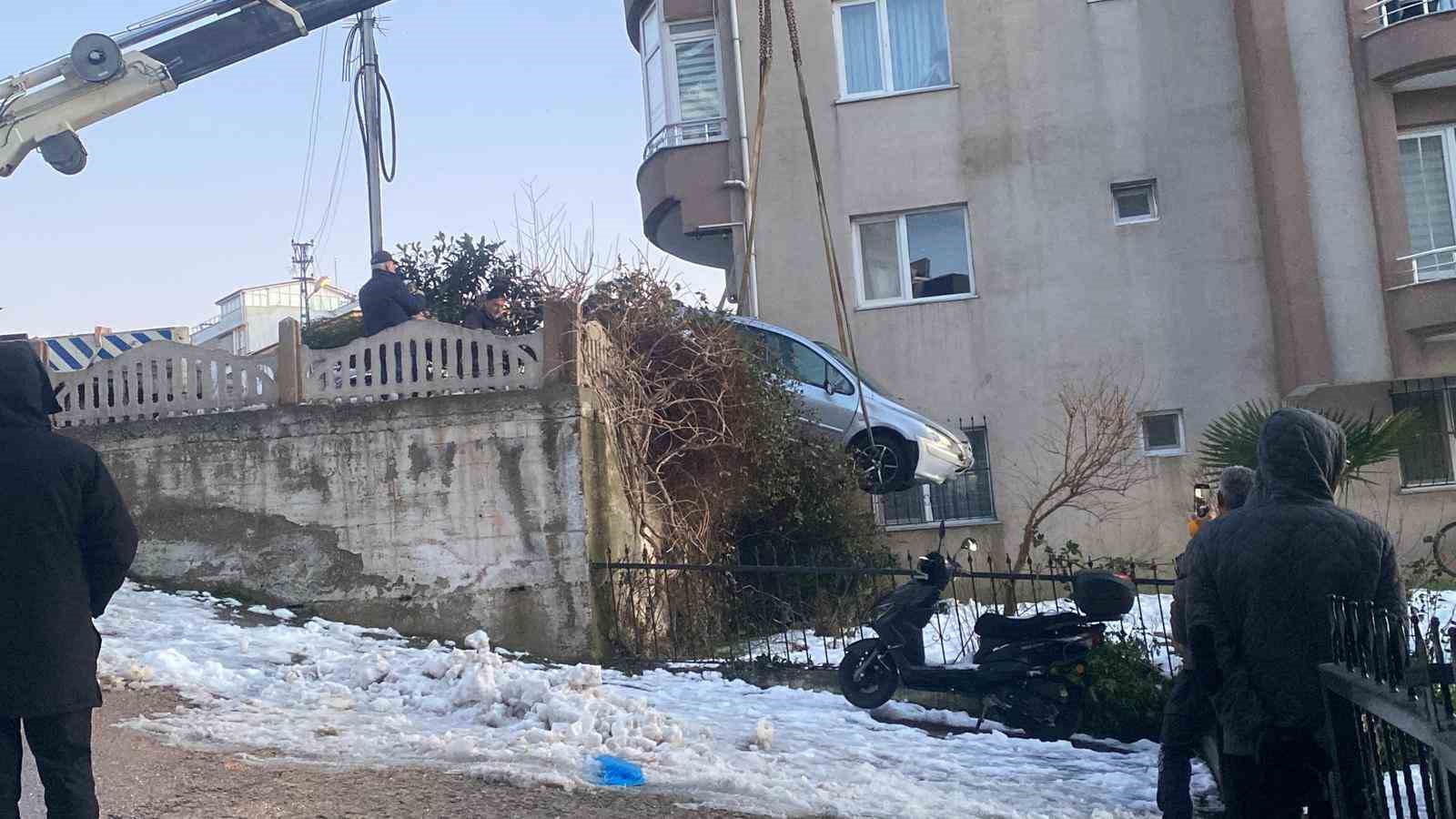 Buzlanan yolda kayan otomobil apartmanın bahçesine düştü
