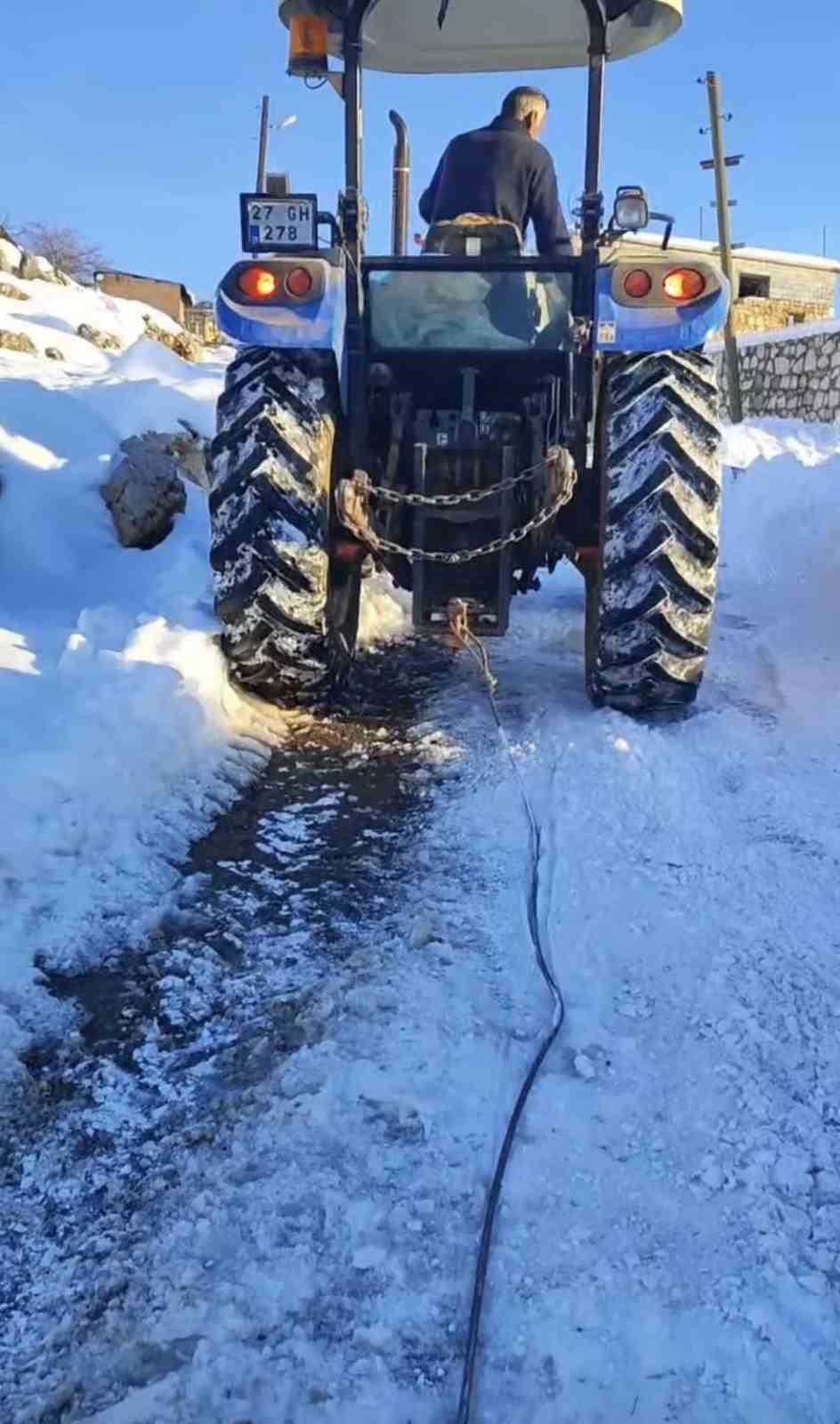Buzlanmış yolda üç traktörü birbirine bağlayıp su taşıdılar
