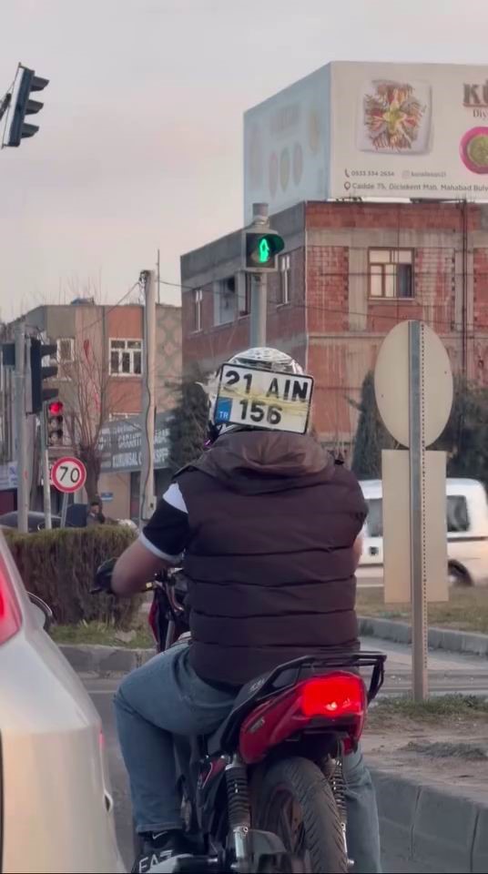 Diyarbakır’da ilginç görüntü: Düşen plakasını kaskına bantlayıp trafikte ilerledi

