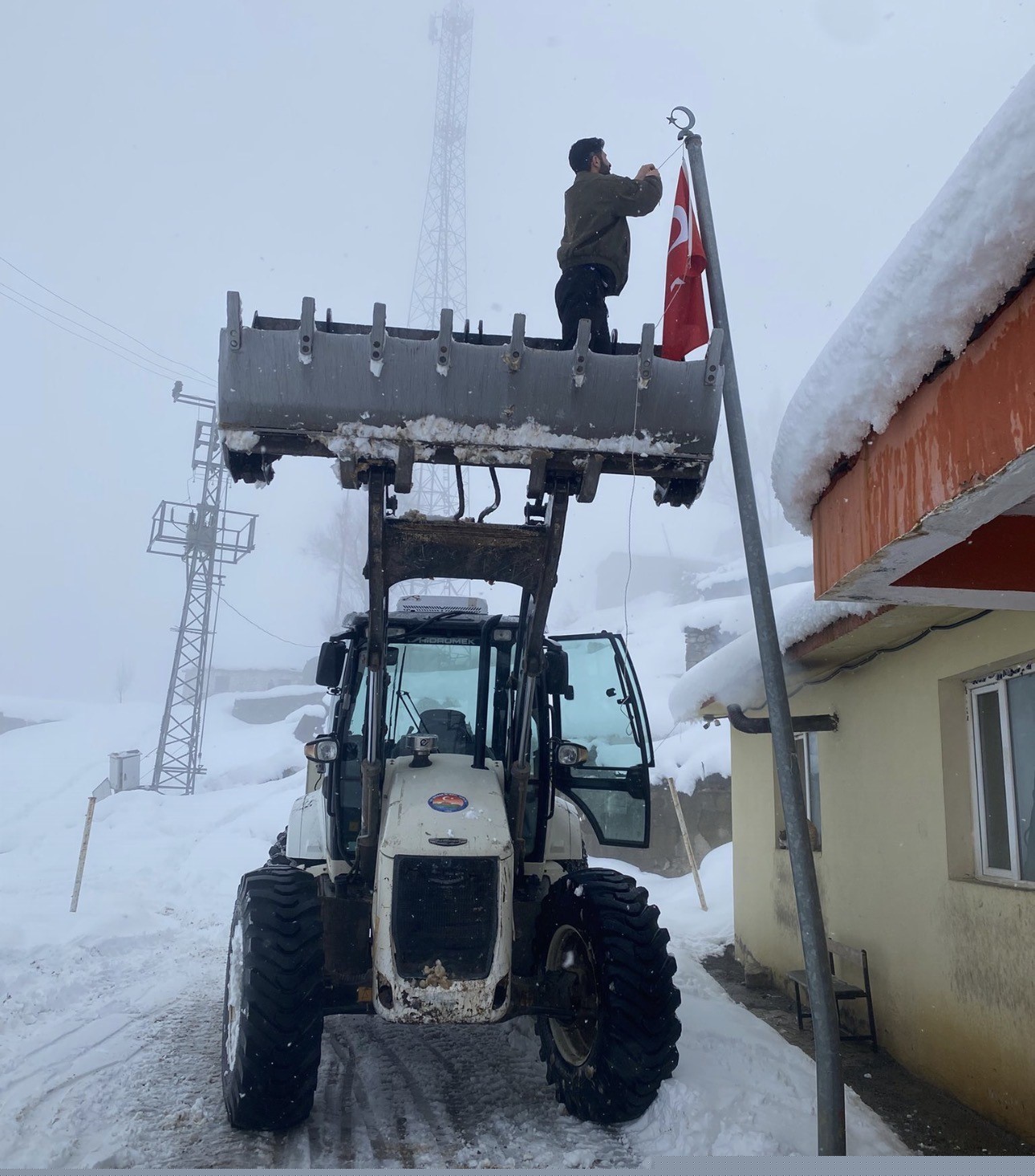 Düşen bayrağı kepçenin ağzına çıkarak yerine taktılar
