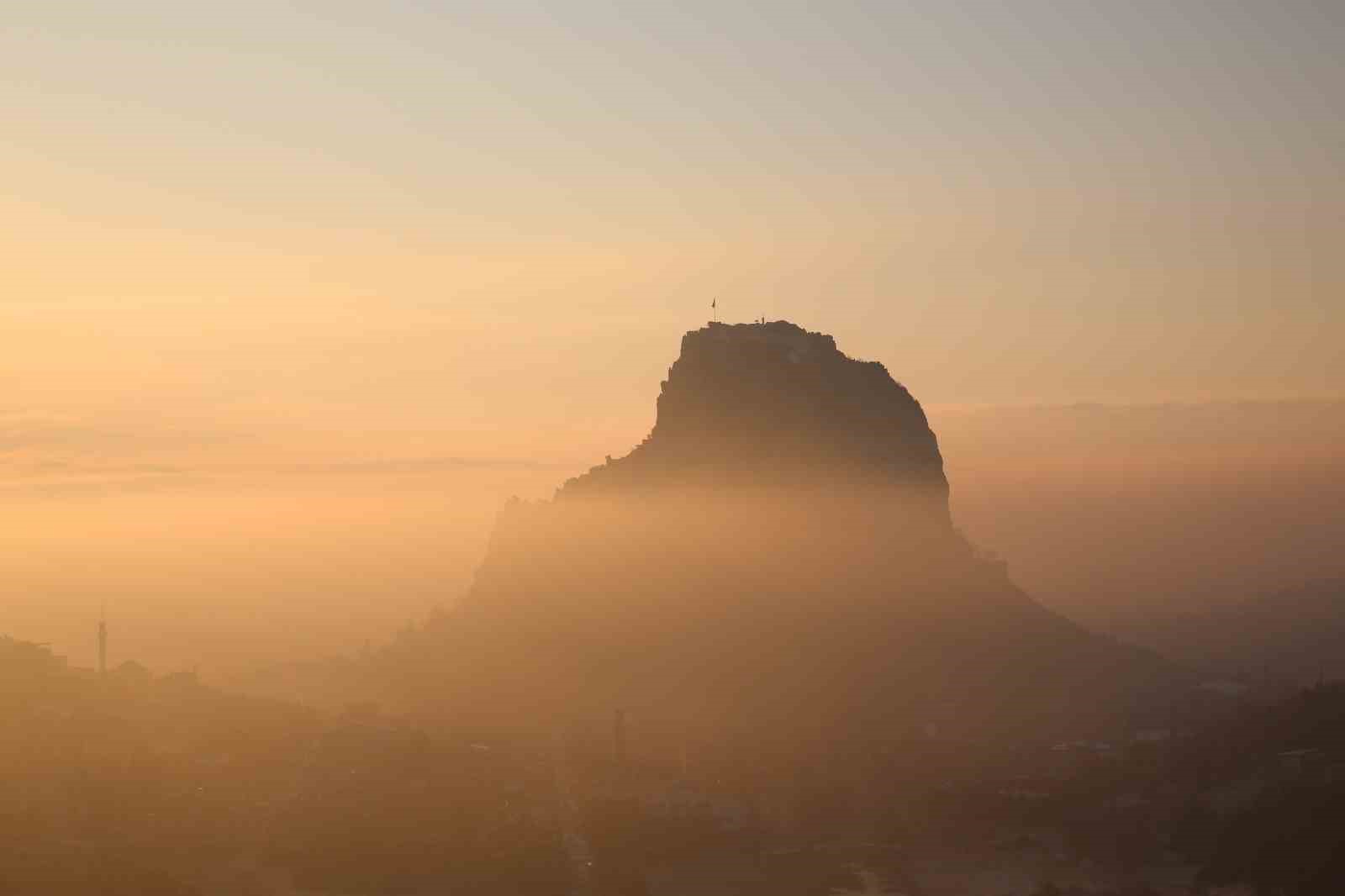 Gün doğumunda sis altında kalan kale kendisine hayran bıraktı
