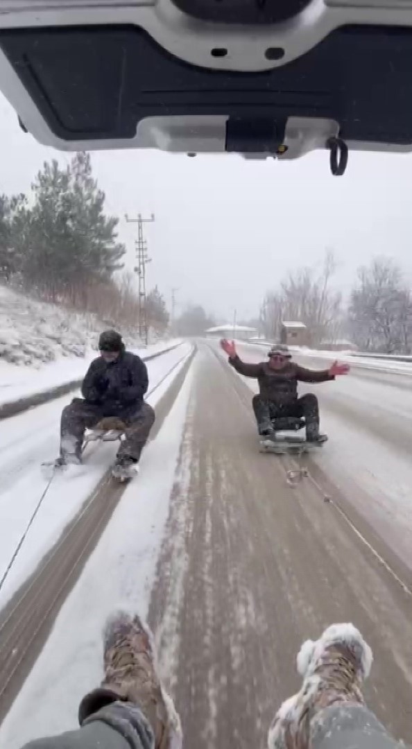 Kar yağışını aracın arkasına bağlanan kızaklarla kutladılar

