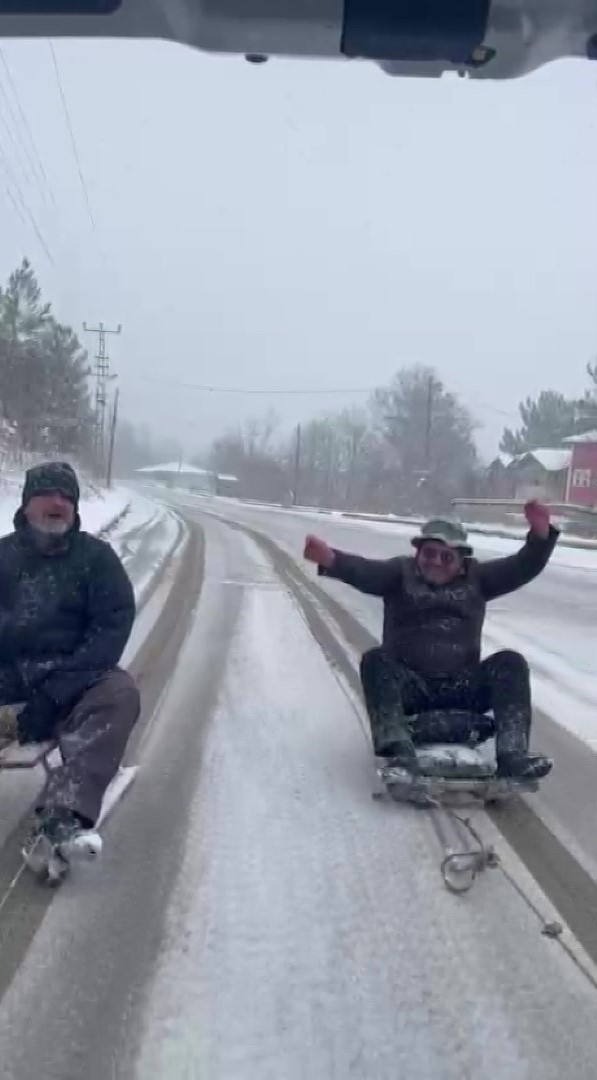 Kar yağışını aracın arkasına bağlanan kızaklarla kutladılar
