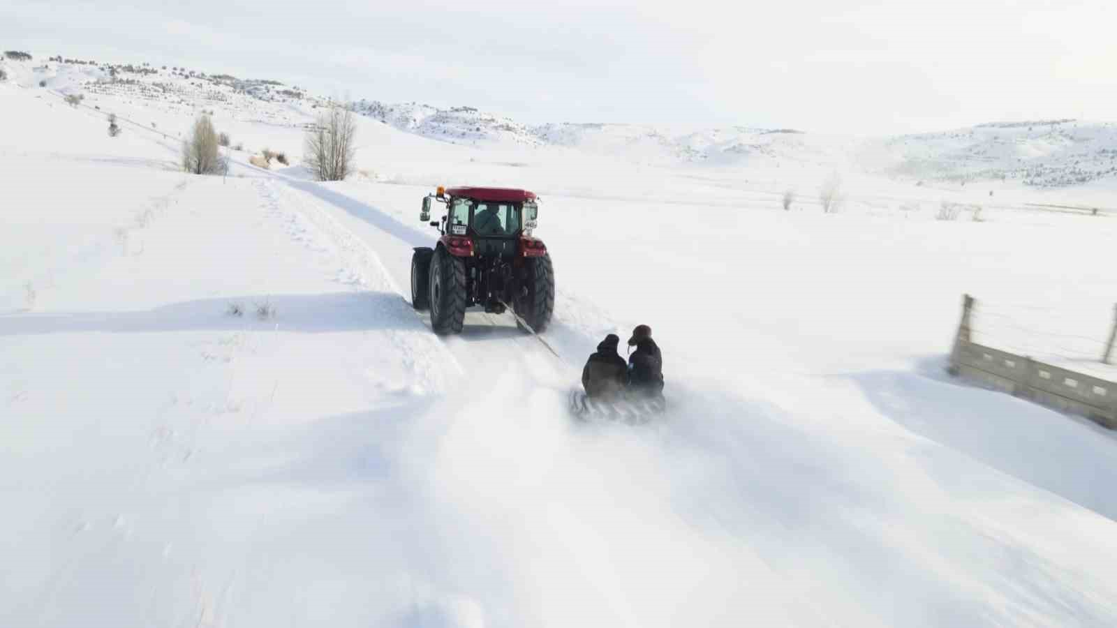 Kar yağışını fırsata çevirdiler, traktörün arkasında kayarak eğlendiler
