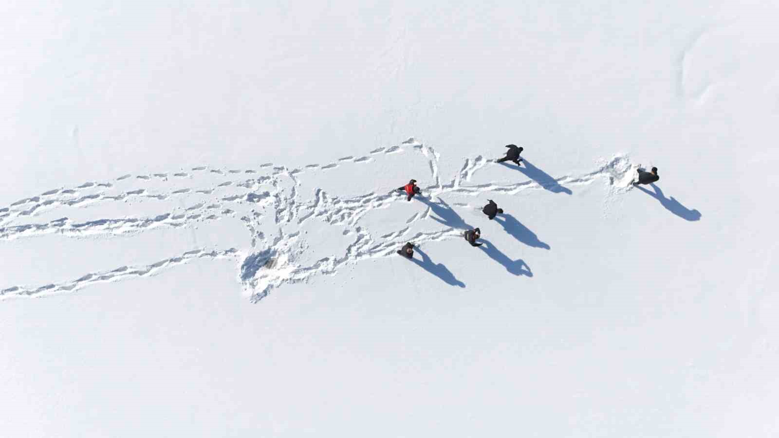 Karla kaplı dağdan donmuş gölete botla kaydılar
