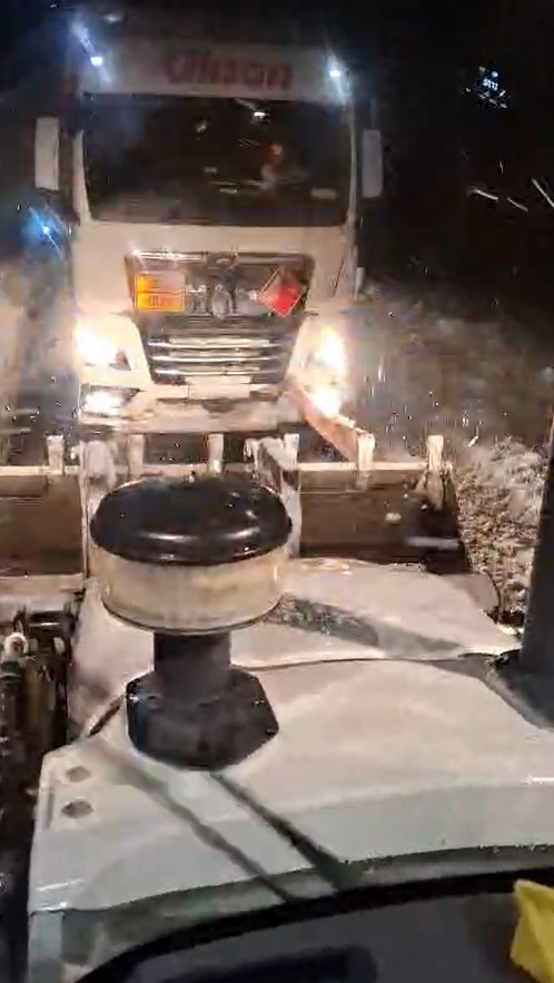 Karlı yolda mahsur kalan tır, iş makinesiyle kurtarıldı
