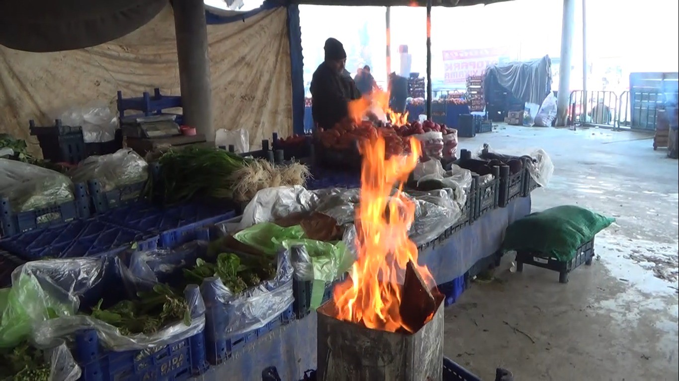 Kütahyalı pazarcılar tenekede ateş yakarak ısınıyor
