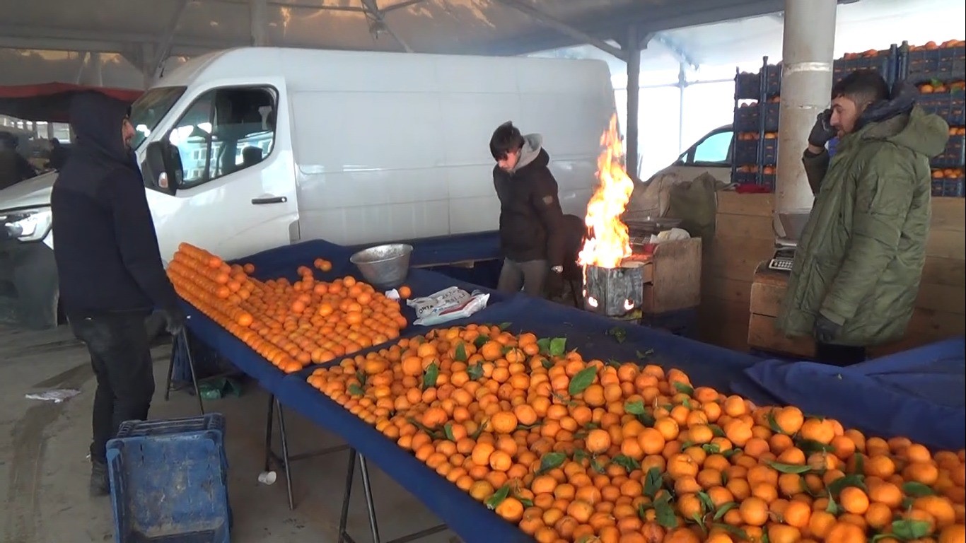 Kütahyalı pazarcılar tenekede ateş yakarak ısınıyor
