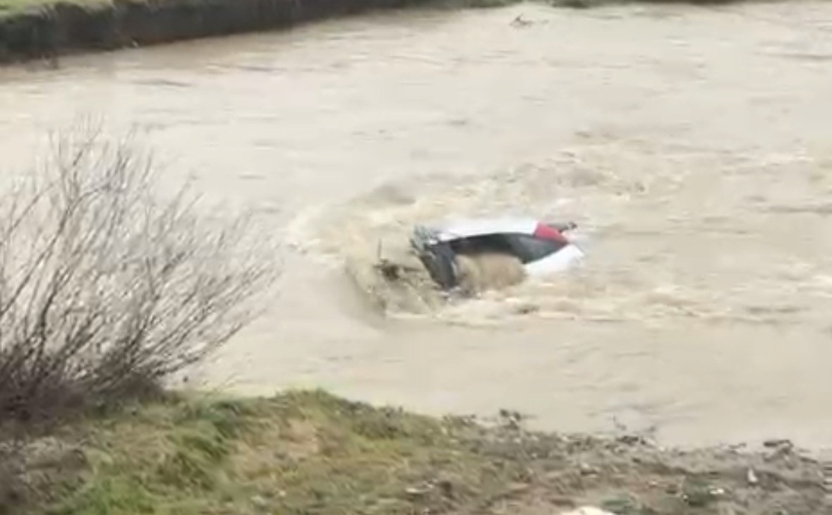 Sürücü kıyıya çıktı, otomobil suda kaldı: Vatandaşlar halatla müdahale etti
