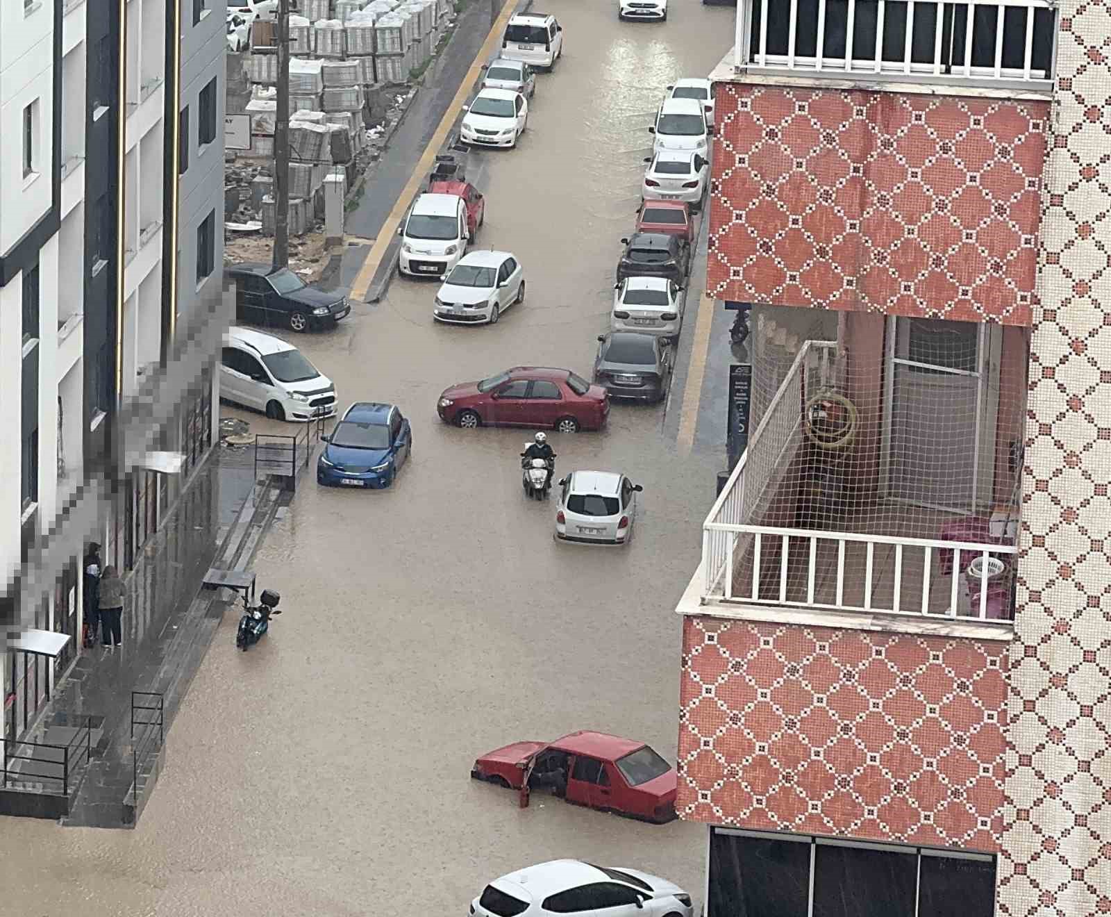 Yağmurda mahsur kalan motosikletli çareyi otomobilin üzerine çıkmakta buldu
