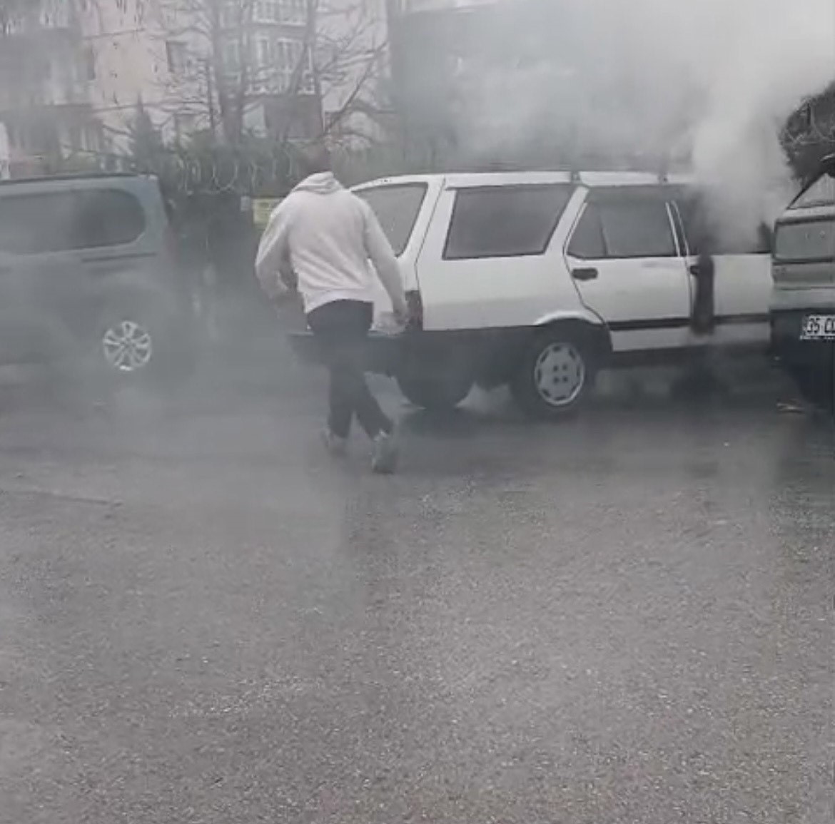 Yanan otomobile yol kenarındaki su birikintisinden doldurduğu kovayla müdahale etti
