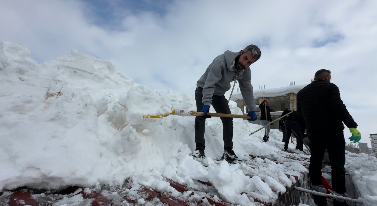 Yüksekova’da 20 kişilik ekibin çatıda kar temizleme mesaisi
