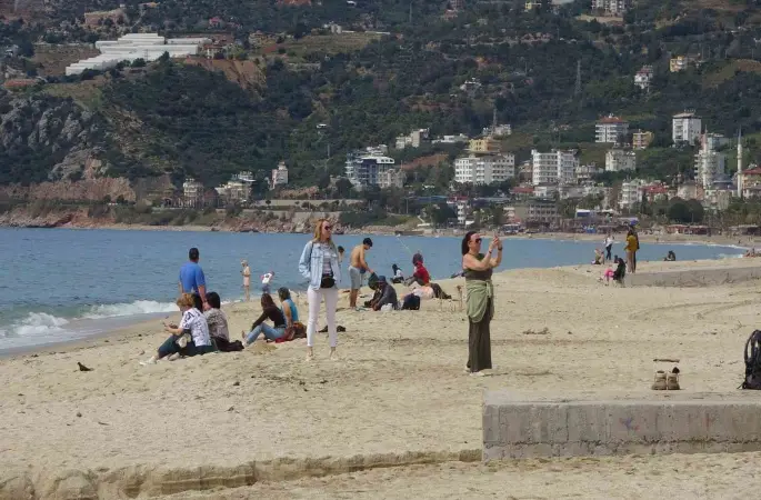Alanya’da bayram arifesinde hava sıcaklığı 20 dereceye ulaştı, tatilciler soluğu sahilde aldı
