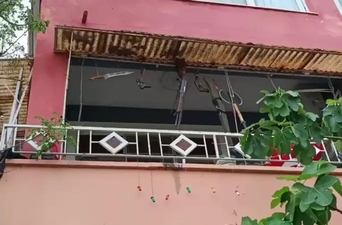 Balkonda silah, balta ve kılıç sergileyen şahıs hayrete düşürdü
